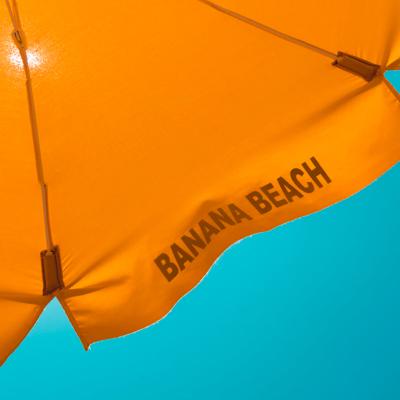 a segment of an orange beach umbrella with 'banana beach' printed on it